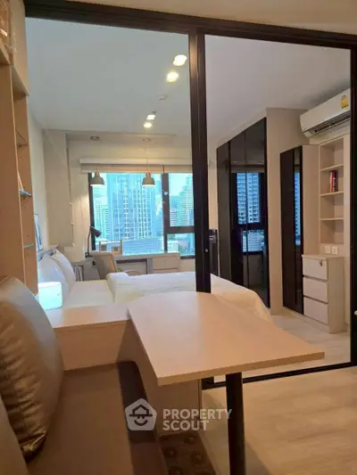 Modern studio apartment with city view, featuring open layout and stylish furnishings.