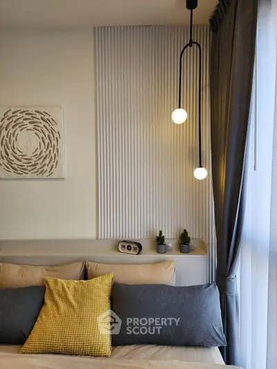 Modern bedroom with stylish lighting and cozy decor, featuring a plush bed and elegant curtains.