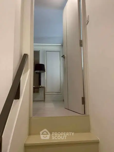 Chic modern interior with sleek staircase leading to a stylish room, perfect for urban living.