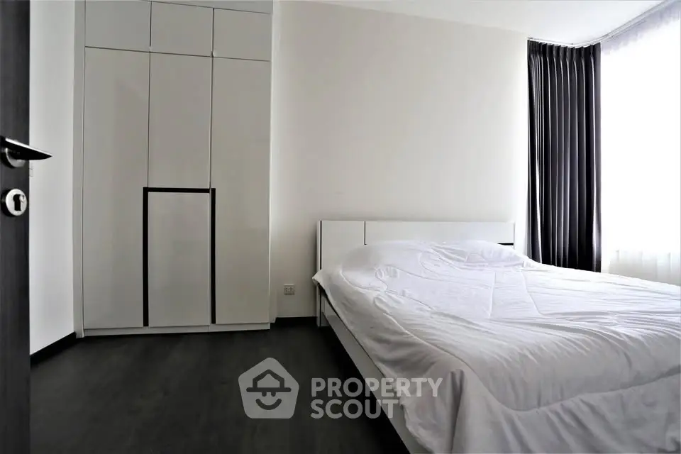 Modern minimalist bedroom with sleek wardrobe and natural light