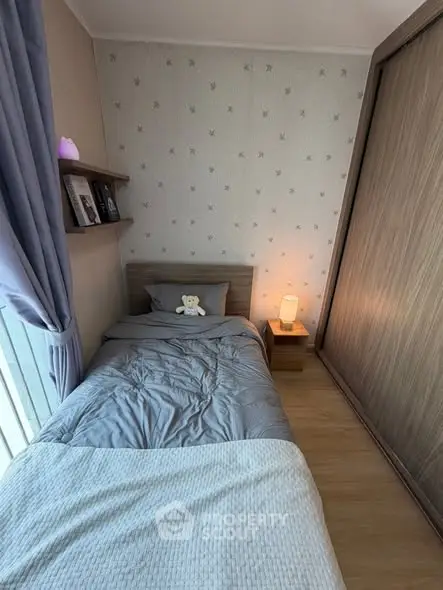 Cozy bedroom with modern decor and ample natural light, featuring a single bed and stylish wooden wardrobe.