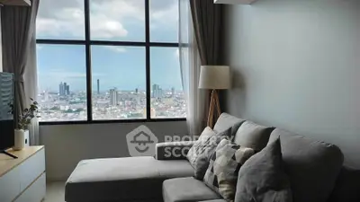 Modern living room with panoramic city view, featuring stylish gray sofa and floor lamp.