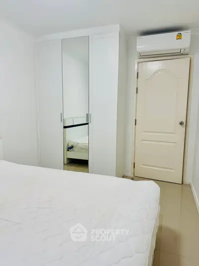 Bright bedroom with mirrored wardrobe and air conditioning unit