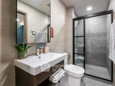Modern bathroom with sleek design, glass shower, and stylish vanity in contemporary home.