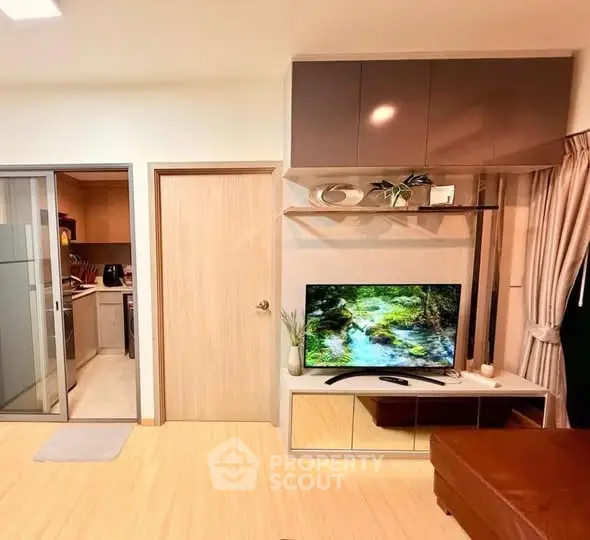 Modern living room with sleek TV setup and adjacent kitchen area.