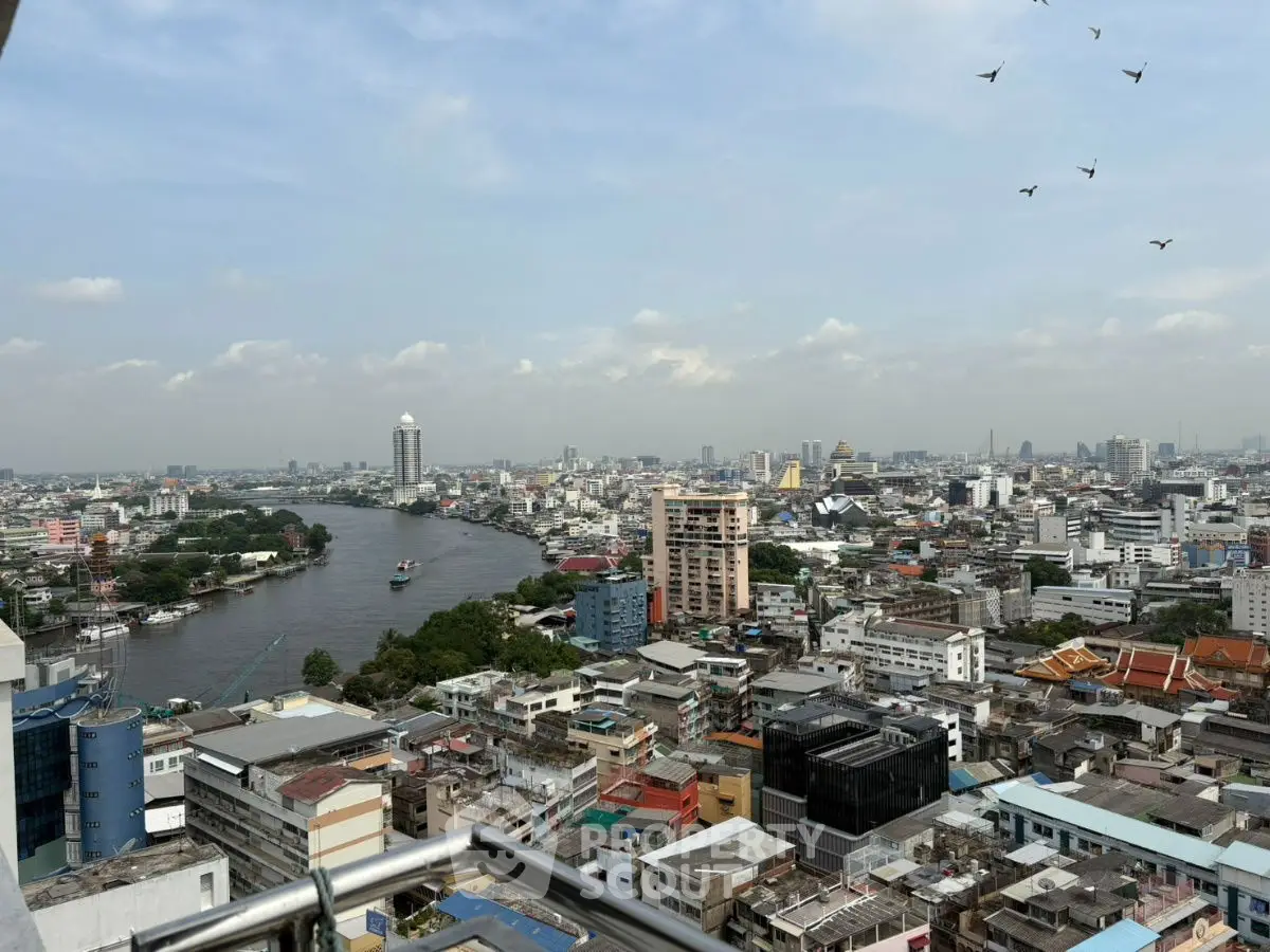 Stunning cityscape view from high-rise balcony overlooking river and skyline.