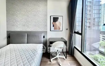 Modern bedroom with stylish decor and city view, featuring a cozy bed and sleek workspace.