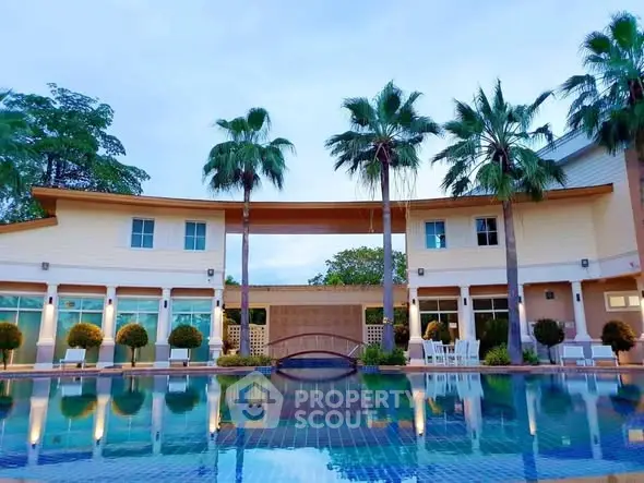 Luxurious villa with stunning pool and palm trees, perfect for serene living.