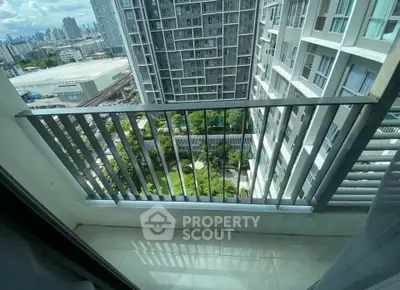 High-rise apartment balcony with cityscape view and lush greenery below.