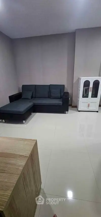 Spacious living room with modern sofa and sleek cabinet, perfect for contemporary living.