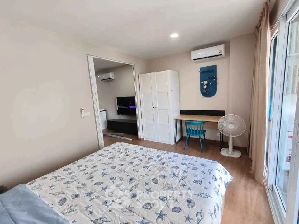 Cozy bedroom with stylish decor, featuring a comfortable bed, air conditioning, and a workspace with natural light.