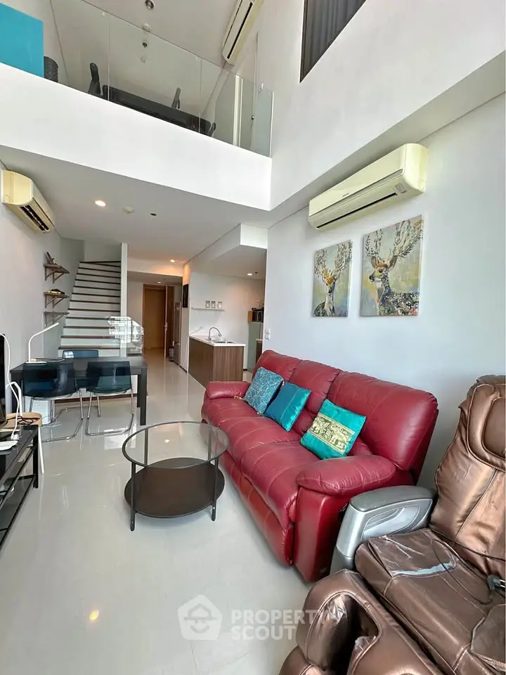 Spacious modern living room with red leather sofa and mezzanine level