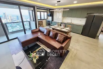 Luxurious open-plan living room with stunning city view, modern kitchen, and elegant leather sofa.