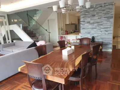 Luxurious open-plan living and dining area with elegant wooden table and modern decor.