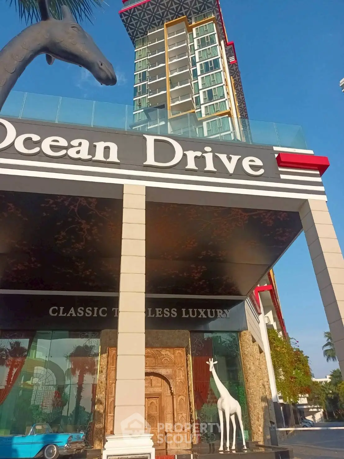 Luxurious modern building entrance with unique giraffe sculptures and classic design elements.