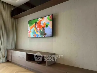 Modern living room with wall-mounted TV and sleek wooden cabinetry.
