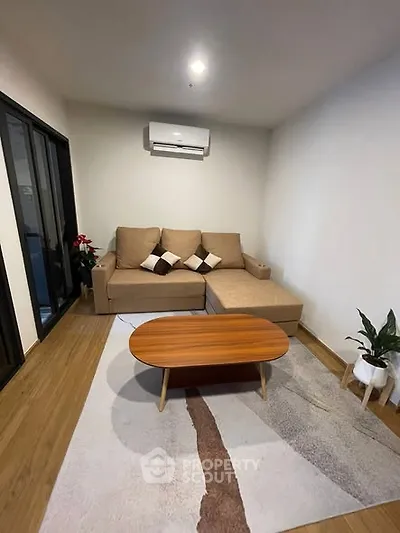 Cozy living room with modern sofa and wooden coffee table, perfect for relaxation.