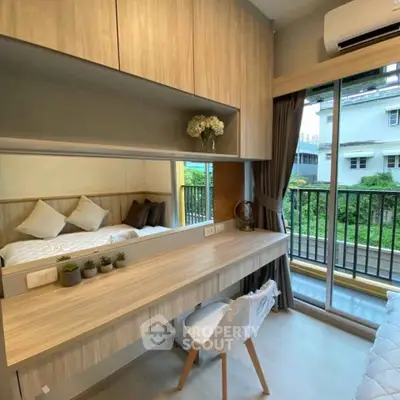 Modern bedroom with balcony view, featuring sleek wooden furniture and stylish decor.