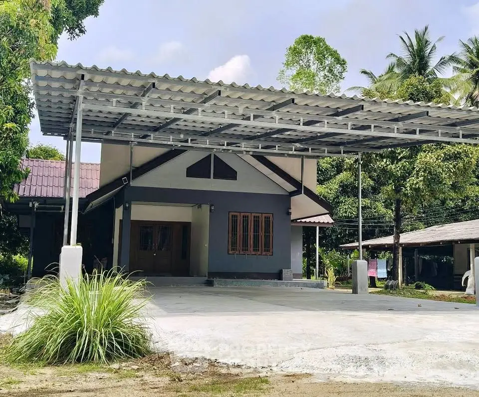 Charming single-story home with spacious carport and lush greenery, perfect for serene living.