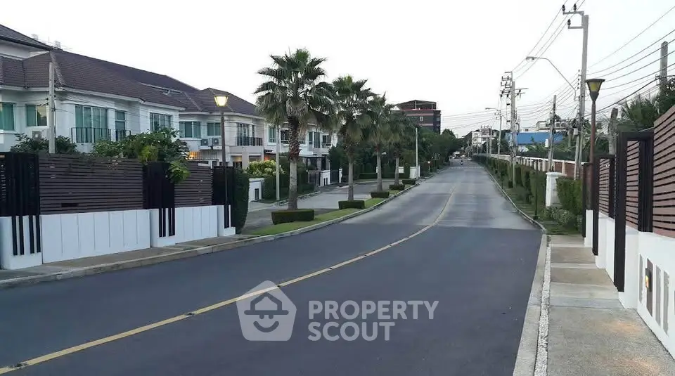 Charming suburban street with modern townhouses and lush greenery.