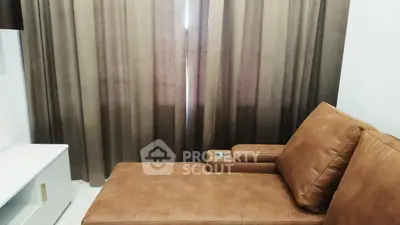 Cozy living room with brown leather sofa and elegant curtains