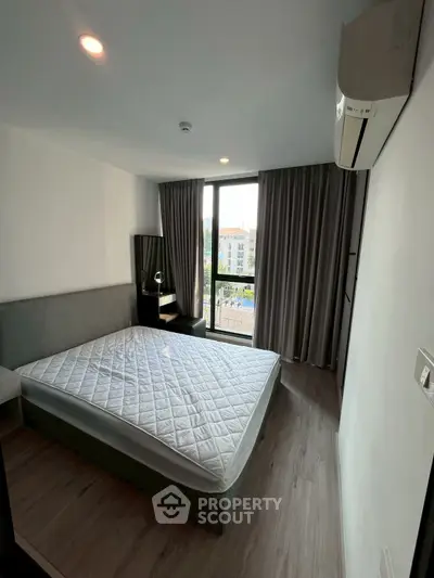 Modern bedroom with large window and air conditioning in stylish apartment