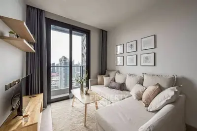 Modern living room with city view, cozy white sofa, and stylish decor.