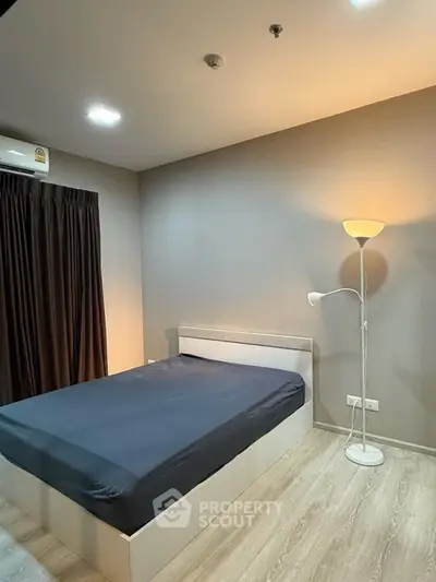 Modern bedroom with sleek design and ambient lighting, featuring a comfortable bed and stylish floor lamp.
