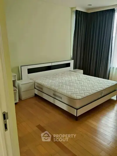 Spacious bedroom with modern design and large window for natural light.