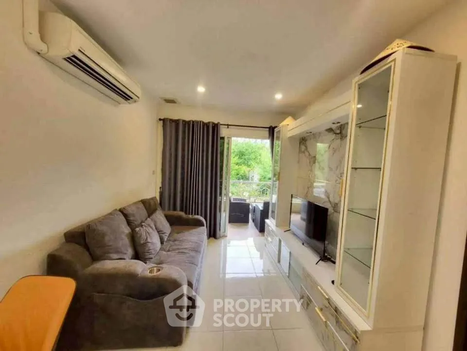Cozy living room with modern sofa, air conditioning, and balcony view.