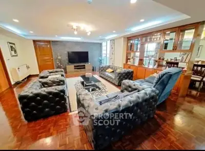 Spacious living room with elegant furniture and wooden flooring, perfect for family gatherings.