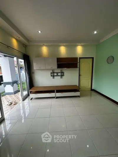 Spacious living room with modern design and large windows opening to a garden view.