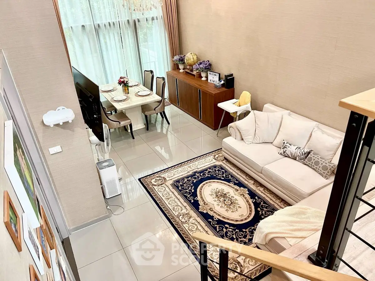 Spacious modern living room with elegant decor and dining area, featuring large windows and stylish furniture.