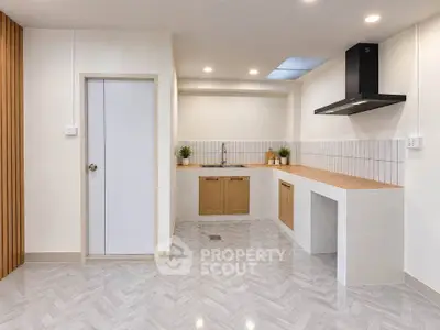 Modern kitchen with sleek design, featuring wooden countertops and ample lighting.