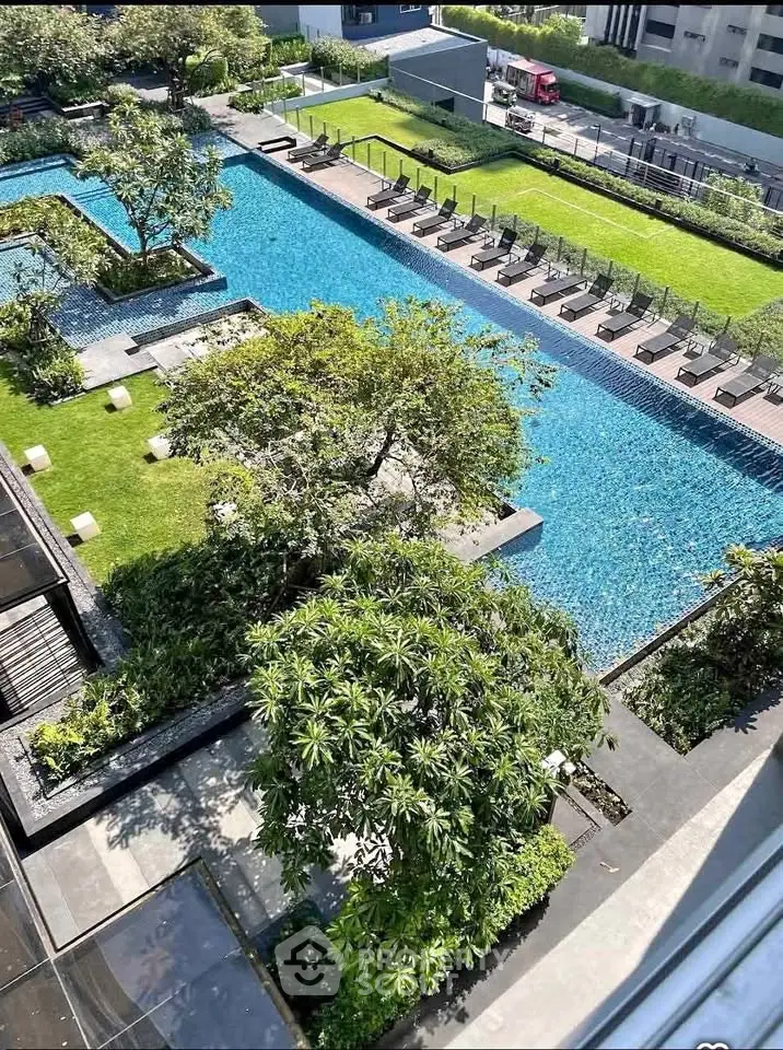 Luxurious rooftop pool with lush greenery and sun loungers in a modern urban setting.