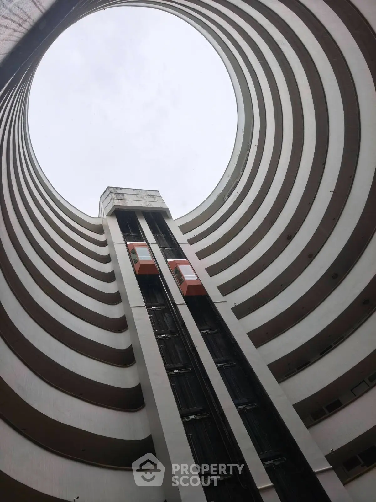 Stunning architectural view of a modern circular building with glass elevators.