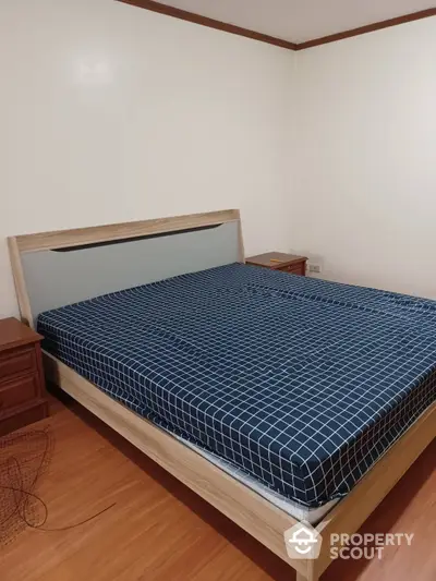 Cozy bedroom with a large bed and matching wooden side tables, featuring warm lighting and a clean, minimalist design.