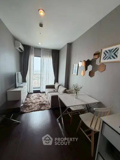 Modern living room with stylish decor and balcony view in a cozy apartment.