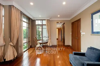 Elegant living room with hardwood floors, large windows, and stylish furnishings in a modern home.