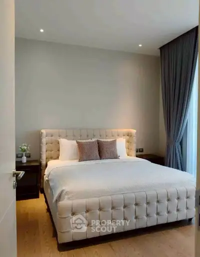 Luxurious bedroom with elegant decor and plush bedding in modern apartment.
