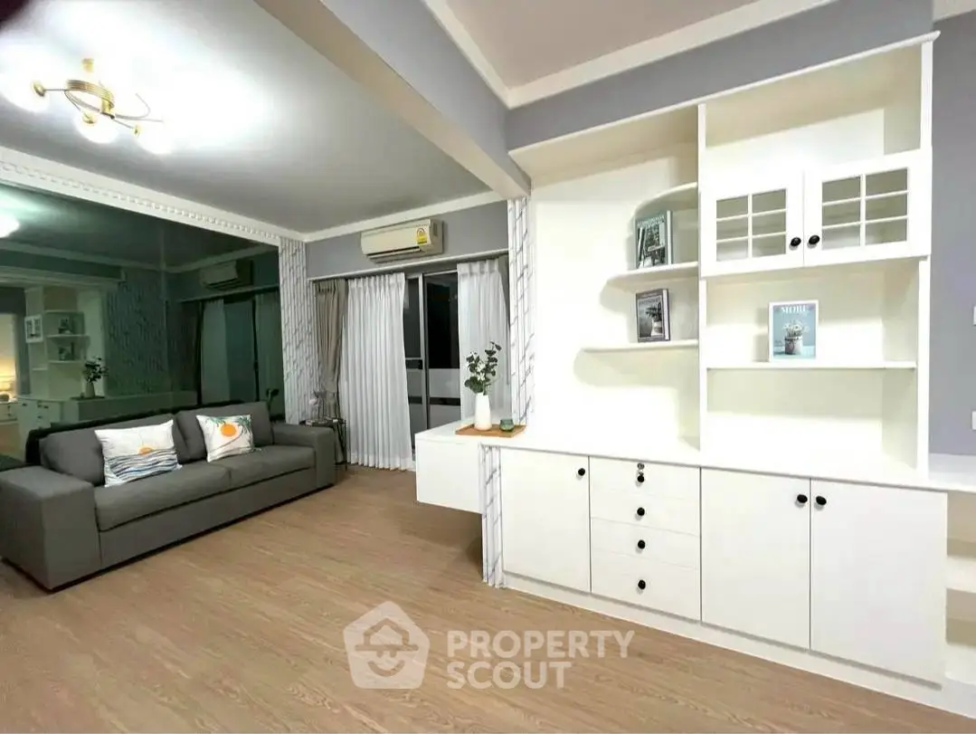 Spacious living room with modern decor and built-in shelving unit, perfect for stylish urban living.