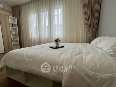 Cozy bedroom with elegant curtains and stylish decor, perfect for relaxation and comfort.