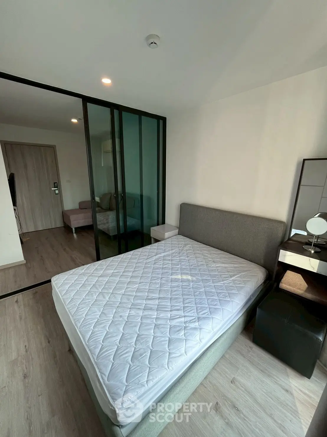 Modern bedroom with glass partition and stylish decor in a contemporary apartment.