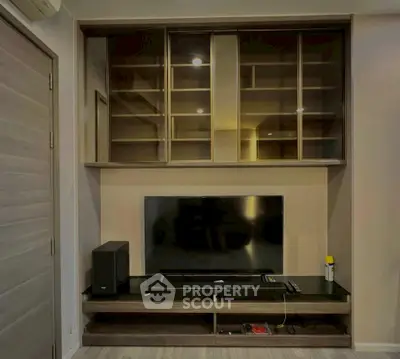 Modern living room with sleek TV unit and ample storage space.