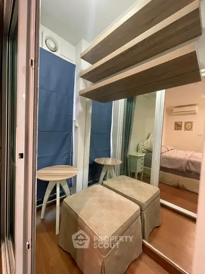 Cozy bedroom with mirrored closet and stylish seating area, perfect for relaxation.