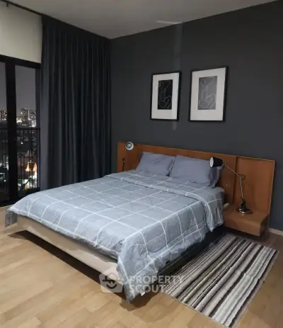Modern bedroom with stylish decor and city view from window, featuring cozy bed and elegant lighting.