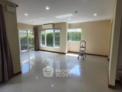 Spacious living room with large windows and garden view, perfect for family gatherings.