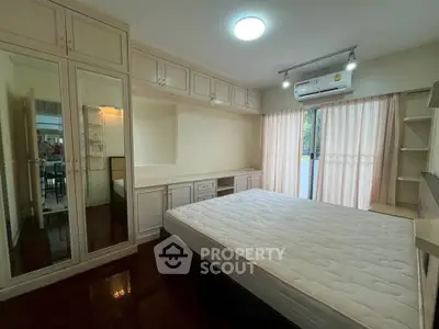 Spacious bedroom with large windows and built-in storage, perfect for modern living.