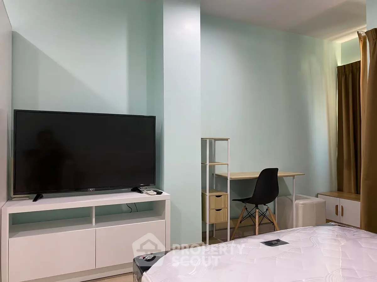 Modern bedroom with TV and study desk, ideal for comfortable living.