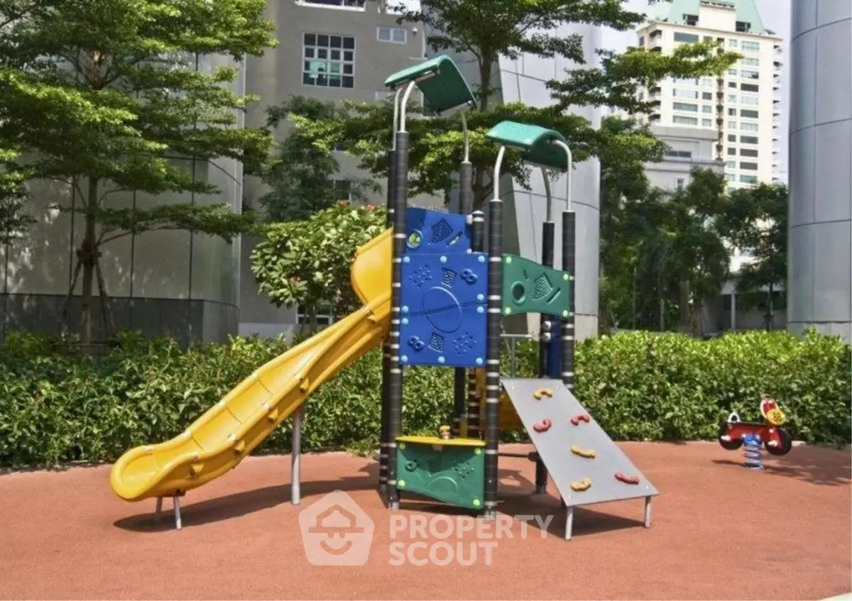 Modern apartment complex playground with colorful slide and climbing features.